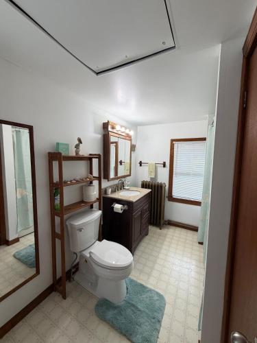 a bathroom with a toilet and a sink and a mirror at Floral Canal-Facing Hideaway in Chesapeake City