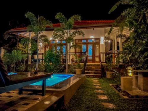 a house with a swimming pool at night at White Villa Goyambokka - Private Pool Villa in Tangalle