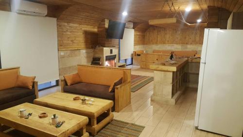 a kitchen with tables and a refrigerator in a room at Villetta di Faraya in Fārayyā