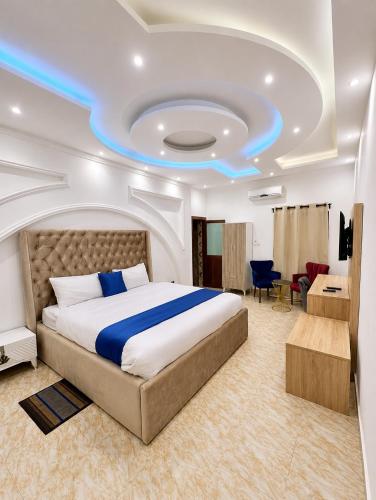 a bedroom with a large bed with a blue light on the ceiling at Valero Hôtel in Cotonou