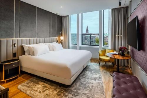 a hotel room with a bed and a large window at NH Collection Copenhagen in Copenhagen