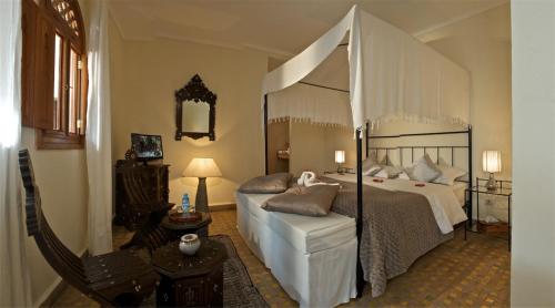 a bedroom with a large bed with a canopy bed at Riad Dar L'Oussia & SPA in Essaouira