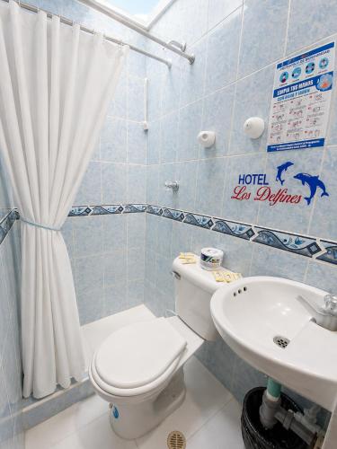 a bathroom with a toilet and a sink at Hotel Los Delfines Melgar in Melgar