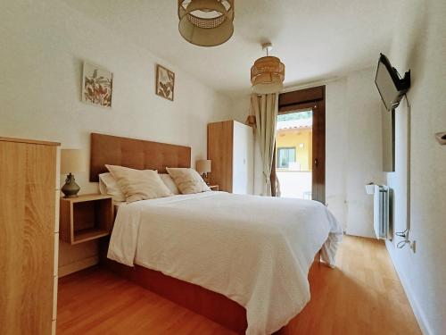 a bedroom with a large white bed and a window at El Llambrion in Posada de Llanes
