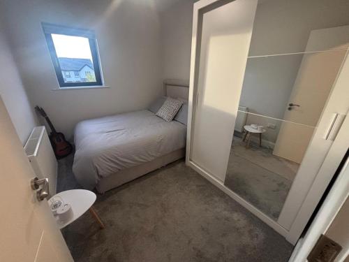 a small bedroom with a bed and a mirror at No2 WestPoint Donegal Town in Donegal