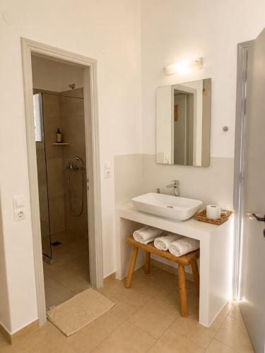 a white bathroom with a sink and a shower at Kirki Rooms on the Hill in Parikia