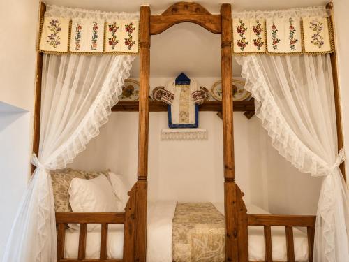 a bedroom with a wooden bunk bed with curtains at Rou Garden House in Karpathos