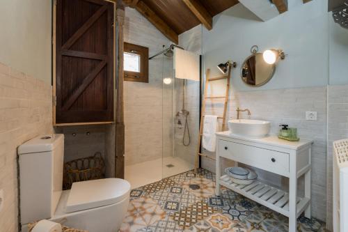a bathroom with a toilet and a sink and a shower at Ático FUENTE HERVERA in Vega de San Mateo