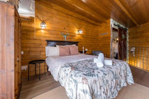 a bedroom with a bed in a wooden cabin at Ático FUENTE HERVERA in Vega de San Mateo
