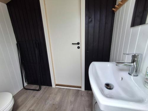 a bathroom with a white sink and a toilet at Vrensted Hostel B&B in Løkken