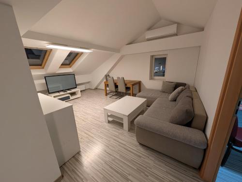 a living room with a couch and a tv at Mainrooms Kelsterbach in Kelsterbach