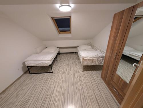 a small room with two beds and a door at Mainrooms Kelsterbach in Kelsterbach
