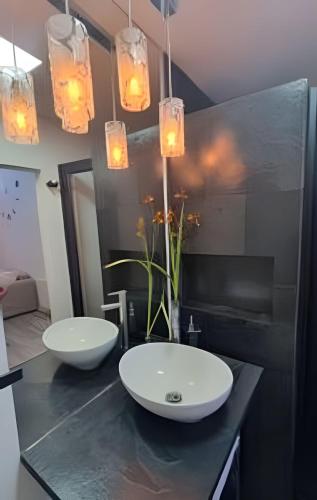 two sinks on a counter in a bathroom with lights at Comfort, Innovation, Style, WiFi, Gym in Coihaique