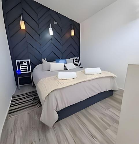 a bedroom with a large bed and a black wall at Comfort, Innovation, Style, WiFi, Gym in Coihaique