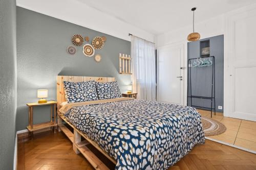 a bedroom with a bed with a blue and white comforter at Charming city in Lausanne