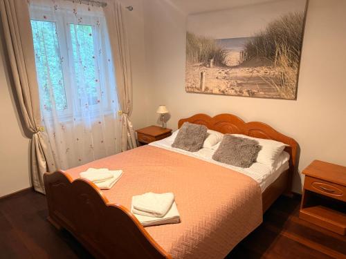 a bedroom with a bed with two towels on it at Lawendowa Ostoja - dom na wyłączność in Uście