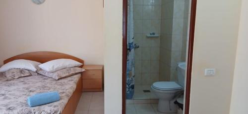 a bedroom with a bed and a bathroom with a toilet at Vila Angeli in Techirghiol