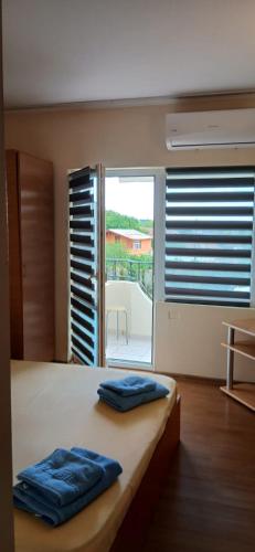 a bedroom with a bed with two blue pillows on it at Vila Angeli in Techirghiol