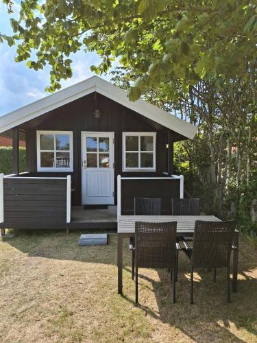 a small house with a table and chairs in front of it at Vrensted Hostel B&B in Løkken