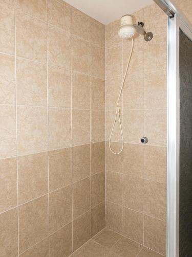 a bathroom with a shower with a glass door at Villa Santa Terezinha in Mesquita