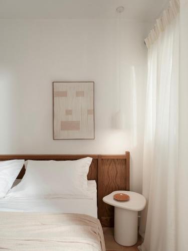 a bedroom with a white bed and a table at Villa Sol Mare Naousa, Paros in Naousa