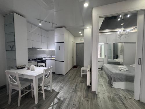 a kitchen and a bedroom with a table and a bed at Apartament in Batumi