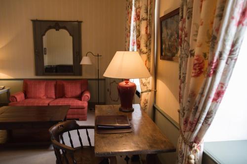 a living room with a table and a red couch at Hotel Château Bela in Belá