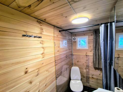 a bathroom with wooden panel walls and a toilet at The Perfect Stop - Viking Haven in Lødingen