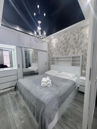 a bedroom with a bed with two shoes on it at Apartament in Batumi