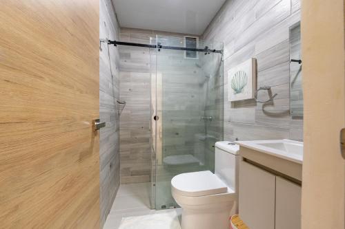 a bathroom with a shower and a toilet and a sink at Rooftop Penthouse Jacuzzi, 2 Pools Playa Popy 500m in Las Terrenas