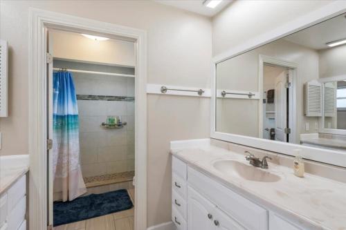 a white bathroom with a sink and a mirror at Sea Breeze 101 Beach Bliss in St. Pete Beach