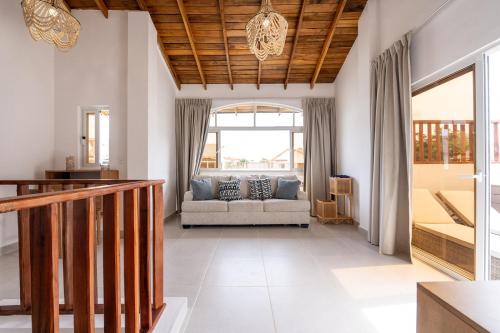 a living room with a couch and a window at Rooftop Penthouse Jacuzzi, 2 Pools Playa Popy 500m in Las Terrenas
