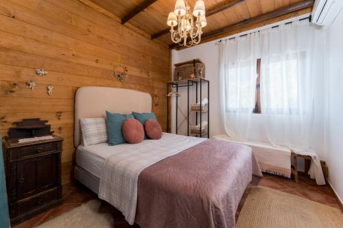 a bedroom with a bed and a chandelier at Casa Fuente Hervera in Vega de San Mateo