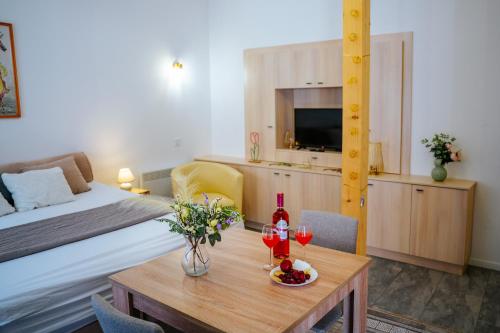 a room with a bed and a table with wine glasses at Infinity Apartman in Esztergom
