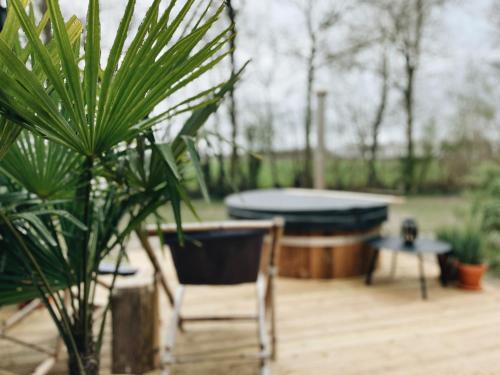 a patio with a table and a chair and a pool table at Tiny Cabin met airco en privé hottub in Rutten