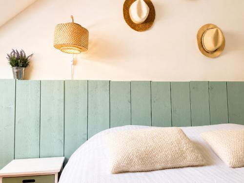 a bedroom with a bed with a green wooden headboard at maison cosy centre ville in Ham