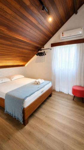a bedroom with a bed with a wooden ceiling at Chalé 17 I Conforto e Lazer na Serra I Gravatá PE in Gravatá