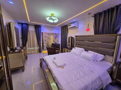 a bedroom with a large bed and a desk at Virginhomes apartment in Jibowu