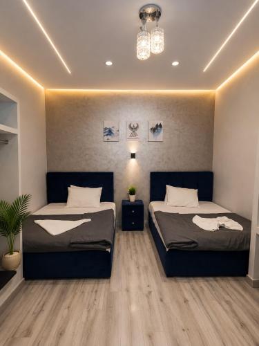 a bedroom with two beds and a chandelier at Royal Moses Pyramids View Hotel in Cairo