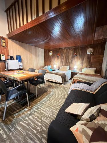 a room with three beds and a table and chairs at Departamento Monoambiente Rústico in Asunción
