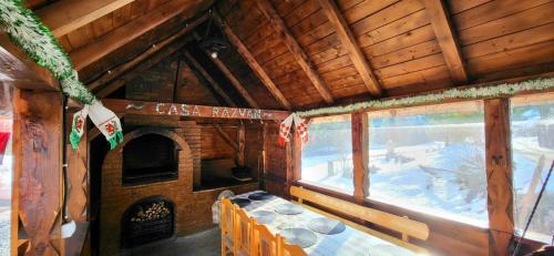 a room with a table and a fireplace in a cabin at Casa Răzvan in Arieşeni