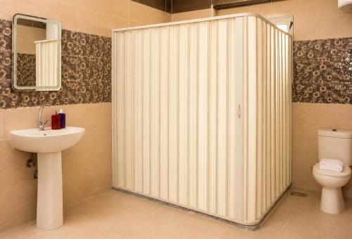 a bathroom with a shower with a toilet and a sink at Roadhouse New Cairo Residence in Cairo