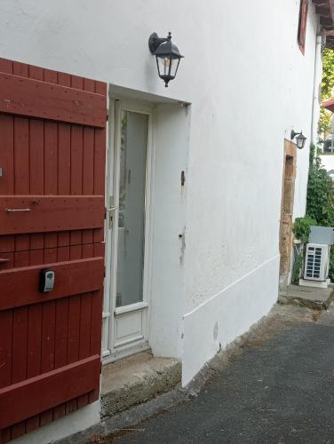 an entrance to a white house with a red door at Maison Belzaenea in Espelette