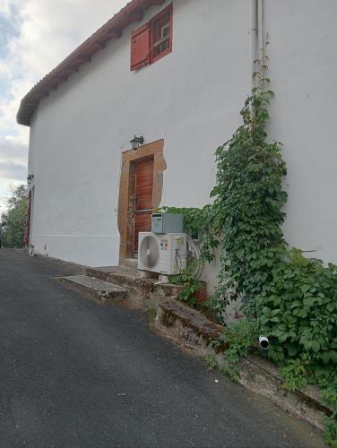 a microwave sitting outside of a house next to a building at Maison Belzaenea in Espelette
