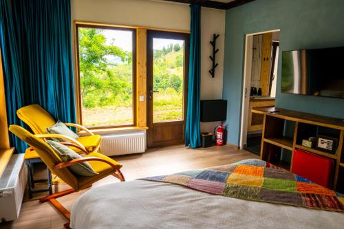 a bedroom with a bed and a chair and a window at K-Home in Stănija