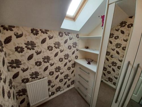 a bathroom with a floral wallpaper on the wall at The Rosewood in Grays Thurrock