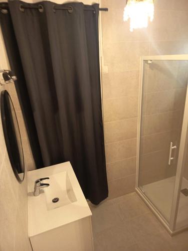 a bathroom with a shower curtain and a sink at SUITE CHARABOIS in Saint-Raphaël