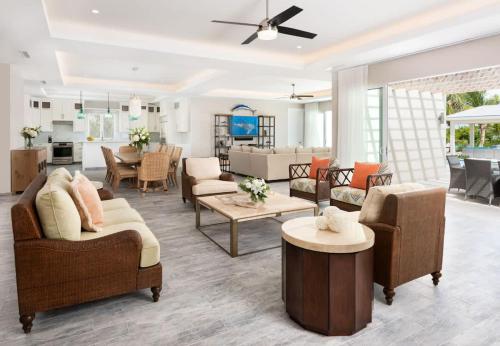 a living room with couches and a dining room at Moringa Villa in Long Bay Hills