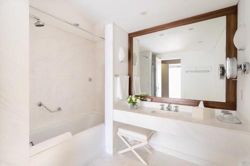a bathroom with a sink and a tub and a mirror at Locanda Punta Del Este in Punta del Este