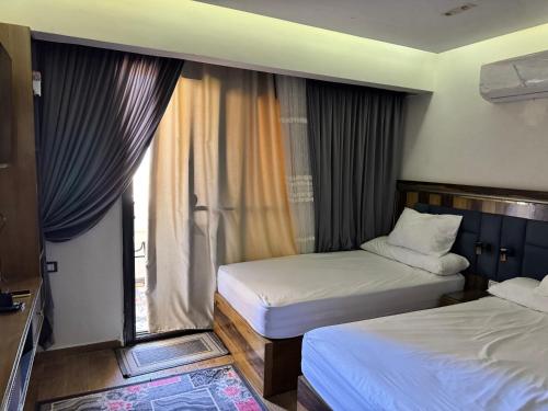 a hotel room with two beds and a window at Helnan portfouad chalet in Chantier Island